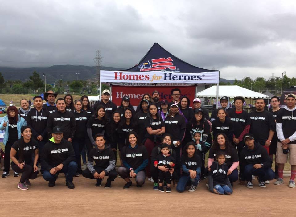 TEAM GOGO SACRED HEART group in front of a Homes for Heroes tent.