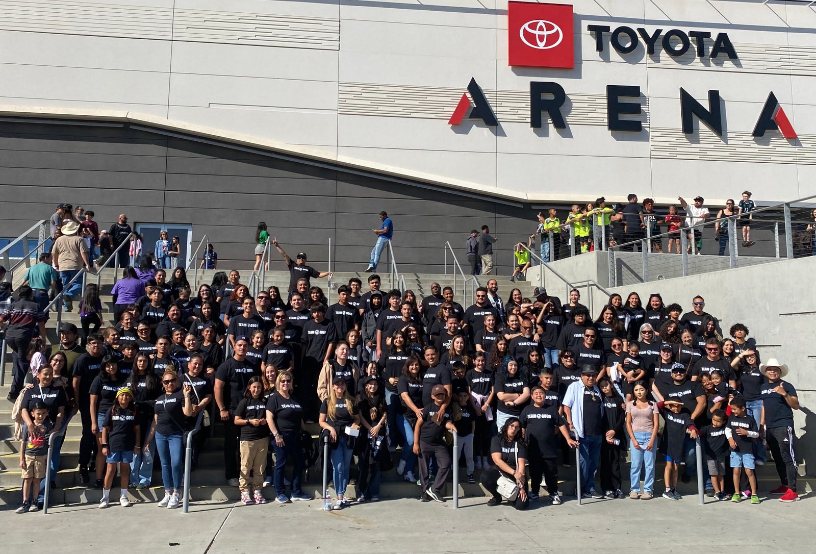 Large TEAM GOGO group gathered on the steps outside Toyota Arena.